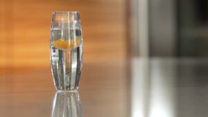 Lypo-Spheric Liposomal Vitamin-C in a small glass of water on table